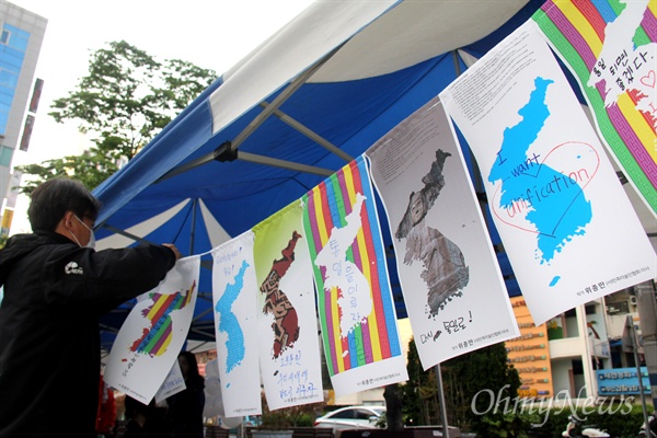  시민들이 25일 오후 창원 상남동 분수광장에서 열린 "남북정상회담 환영 문화제"에서 단일기 달기를 하고 있다.
