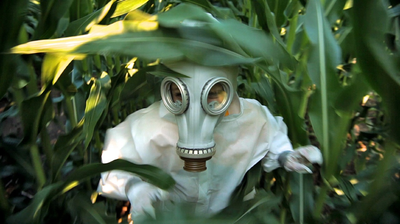  영화 <GMO-OMG >의 한 장면. 방제복과 방독면을 쓰고 들어가야 하는, 살충제를 내뿜는 GMO 옥수수 농장 모습. 