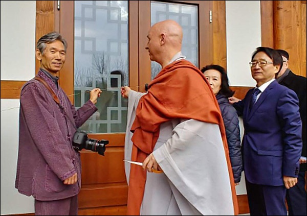 오색실자르기 오색실로 둘러싸인 새법당의 낙성을 알리는 오색실자르기(티이프것팅에 해당)에 앞서 의미를 설명하는 청안스님, 왼쪽은 한옥설계를 맡은 최우성 한겨레건축사사무소 대표, 청안스님 뒤편은 최규식 주헝가리대사 부부