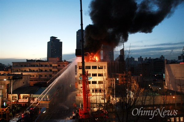 2009년 1월 20일 새벽 서울 용산로2가 신용산역 부근 재개발 지역내 5층 건물 옥상에 설치된 철거민 농성용 가건물이 경찰특공대 진입 과정에서 불길에 휩싸여 시커먼 연기를 내며 무너지고 있다.