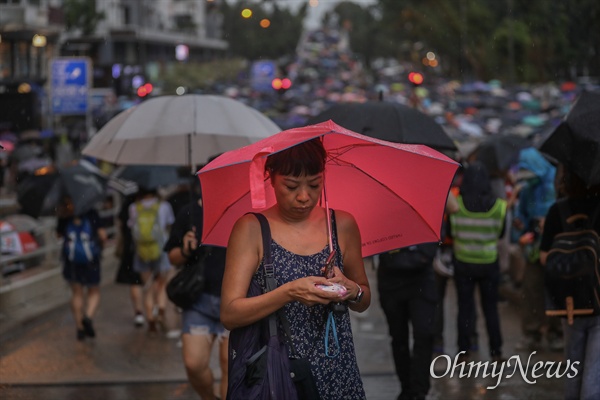 강경진압 경고에도 거리로 쏟아진 홍콩시민들 중국 정부의 강경진압 경고에도 불구하고 18일 오후 송환법에 반대하는 홍콩시민들이 빅토리아 공원을 가득 채워 집회를 성사시킨 뒤, 폭우 속에 거리행진을 하고 있다.
