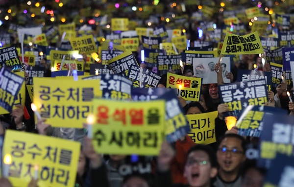19일 오후 서울 서초구 서울중앙지법 인근 서초대로에서 열린 검찰 규탄 촛불집회에서 참가자들이 손팻말을 들고 구호를 외치고 있다.