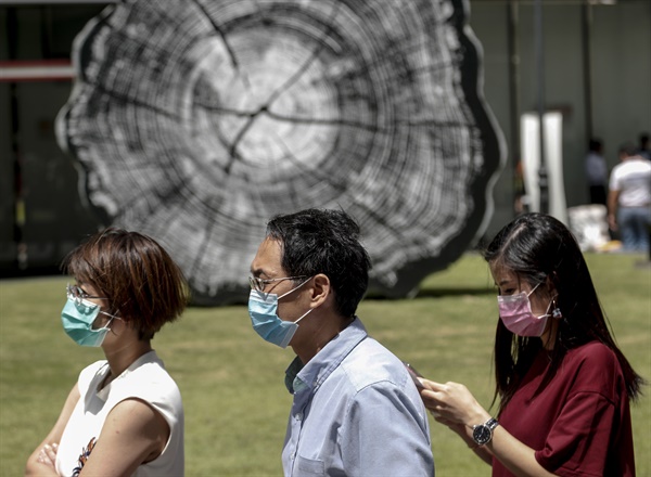 (싱가포르=EPA연합뉴스) 2020년 2월 7일 싱가포르의 금융가에서 사람들이 보호 마스크를 쓰고 있다. 
