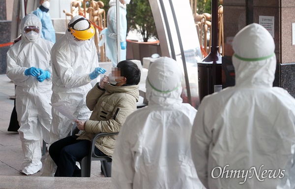  세계보건기구(WHO)가 신종 코로나바이러스 감염증(코로나19)에 대해 펜데믹(세계적 대유행)을 선언한 12일 오후 집단감염이 발생한 서울 구로 콜센터 앞 선별진료소에서 입주민이 감염 검사를 받고 있다.