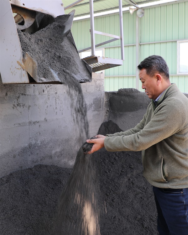 송우산업(주) 강성준 전무이사가 석탄회에서 선별한 순환재생골재의 생산과정을 살펴보고 있다.