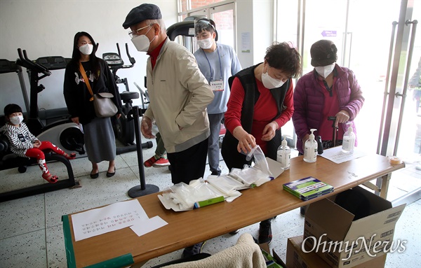  제21대 국회의원선거 투표일인 15일 오후 서울 용산구 성심여중·여고 체육관에 설치된 원효로제2동 제3투표소에서 시민들이 투표를 하기 위해 비닐 장갑을 착용하고 있다.
