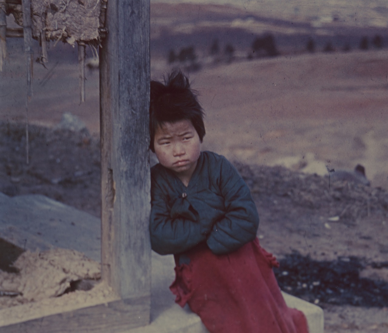  한 소녀가 전란으로 허물어진 집 섬돌에 앉아 우울한 표정을 짓고 있다, 당시 컬러 사진은 무척 귀했는데 NARA에 몇 장 소장돼 있었다(1951. 3. 1. 전주). 