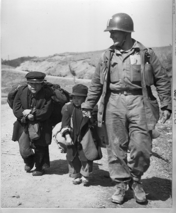   미군이 두 소년의 피란 길을 도와주고 있다(1951. 3. 20.).