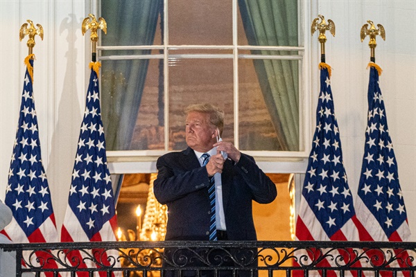  코로나19 확진 판정을 받은 도널드 트럼프 미국 대통령이 백악관 발코니에 서서 마스크를 벗고 있다.