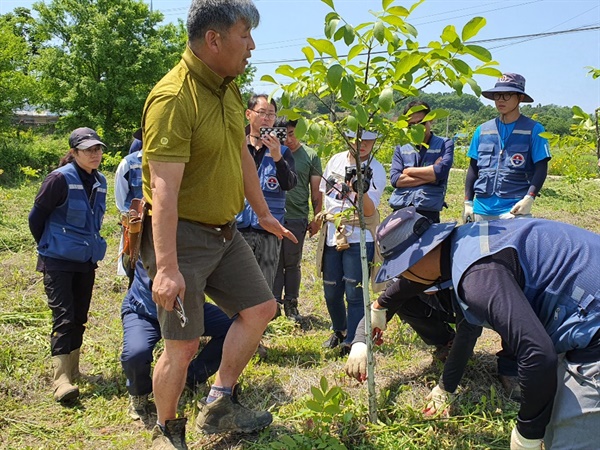 호두 재배에 대한 교육  농업학교 학생들에게 호두나무 재배법에 대한 실습을 시키는 김 성국 씨