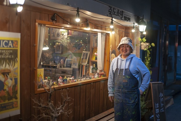  자신이 운영하는 카페 앞에서 환하게 웃고 있는 김희준씨.