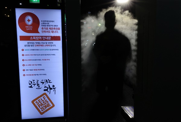  핼러윈 데이를 하루 앞둔 30일 오후 서울 용산구 이태원 거리 입구에 설치된 신종 코로나바이러스 감염증(코로나19) 방역 게이트를 시민들이 통과하고 있다.