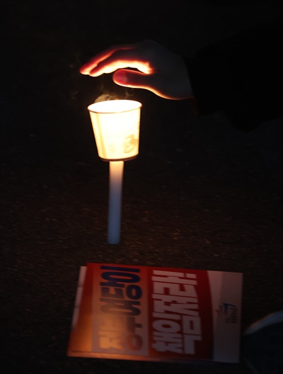  지난 4일 저녁 서울 여의도 더불어민주당사 앞에서 민주노총 전국공공운수노동조합이 연 이스타항공 정리해고 철회 촛불 문화제에서 한 참가자가 차가워진 날씨에 언 손을 녹이고 있다.