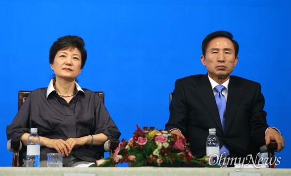  2007년 8월 6일 오후 경남 창원실내체육관에서 열린 한나라당 대선후보자선출을 위한 경남합동연설회에서 박근혜 후보와 이명박 후보가 나란히 앉아서 다른 후보의 연설을 듣고 있는 모습. 
