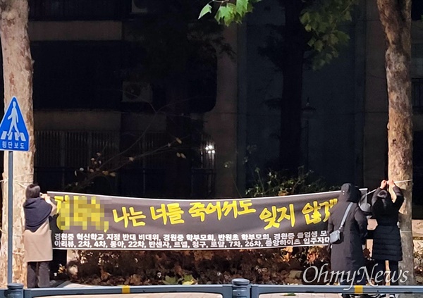  8일 0시 9분쯤, 서울 경원중 주민들이 교장 이름이 적힌 펼침막을 떼어내고 있다. 