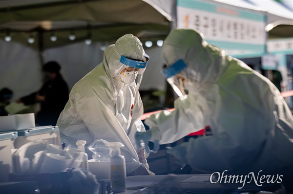 2020년 12월 28일 오후 서울역 광장에 마련된 임시선별검사소에서 의료진이 코로나19 검사를 하고 있다.