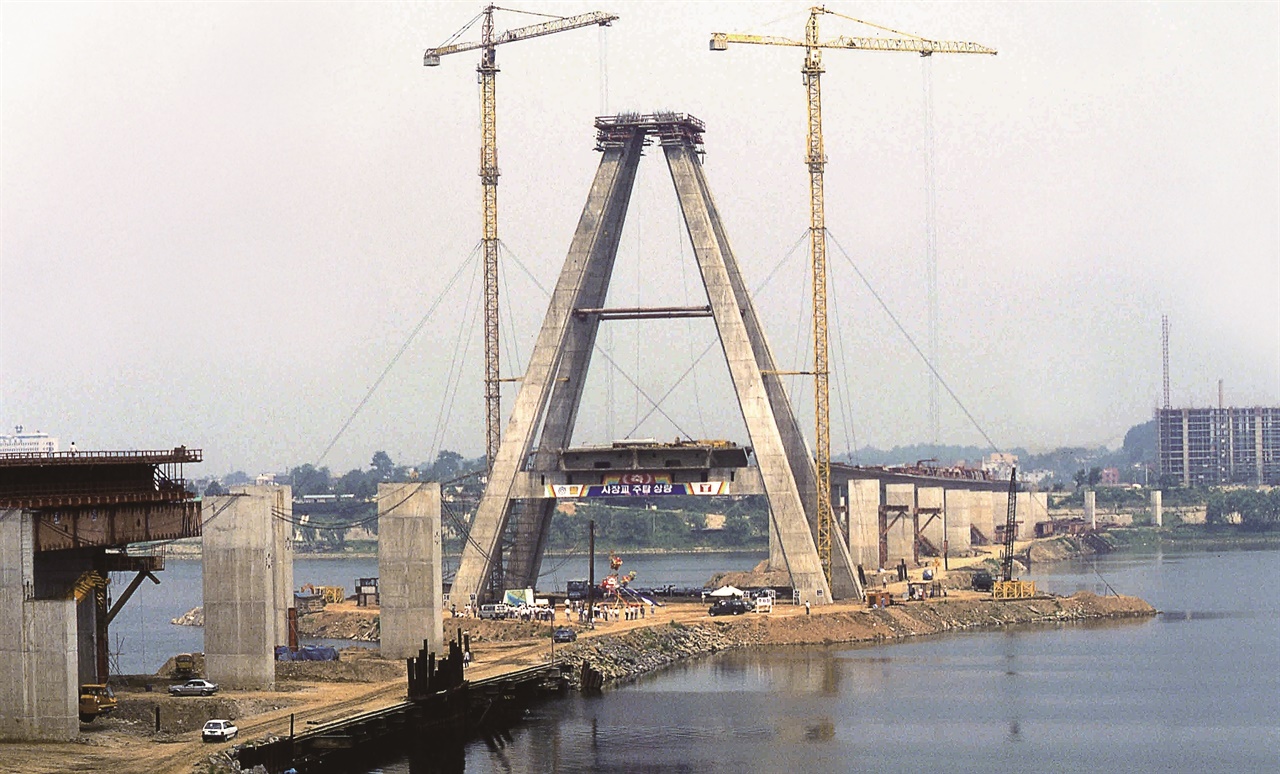 올림픽대교 주탑 상량(1988년 6월) 사장교와 형교의 복합교인 올림픽대교 공사 모습이다. 사진 좌측 형교 부분에 벤트를 설치하여 거더를 가설하는 모습을 볼 수 있다.