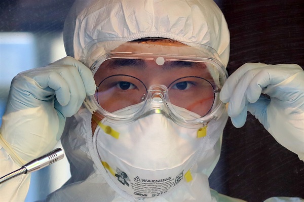   12일 오전 서울역 광장에 마련된 코로나19 임시 선별검사소에서 의료진이 고글을 고쳐 쓰고 있다.