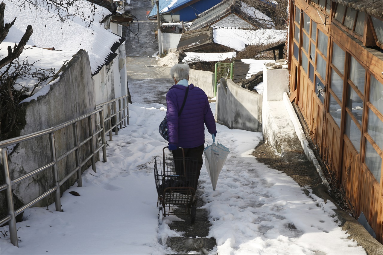  집에서 나온 주민이 죽전골목의 계단을 따라 조심스럽게 내려가고 있다. 눈이 내린 지난 1월 13일 모습이다.