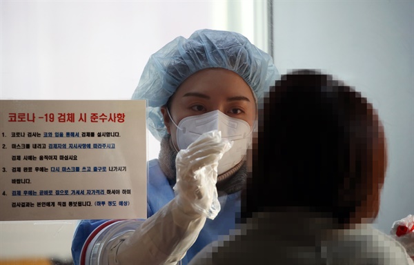 코로나19 확진자가 국내에서 처음 발생한 지 1년째가 되는 1월 20일 오후 광주 북구선별진료소 의료진이 코로나19 검체를 채취하고 있다.