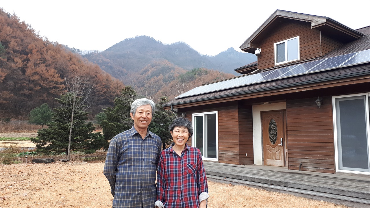  김준권 씨는 올해 한국 나이로 74세가 되었고 원혜덕 씨는 66세를 맞이했다. 나이보다 건강한 활력이 느껴지는 부부의 미소가 아름답다. 뒤에 보이는 집은 부부가 사는 집. 
