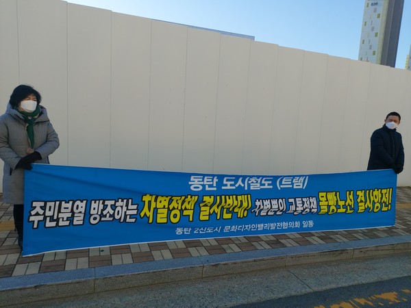  지난해 12월 9일 경기도가 주관한 동탄도시철도 기본계획안 주민공청회장 앞에서 동탄2신도시 주민이 현수막을 들고 서있다.