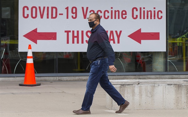 캐나다 온타리오주 미시소거에서 마스크를 쓴 한 남성이 코로나19 백신 접종소에 도착하고 있다. 