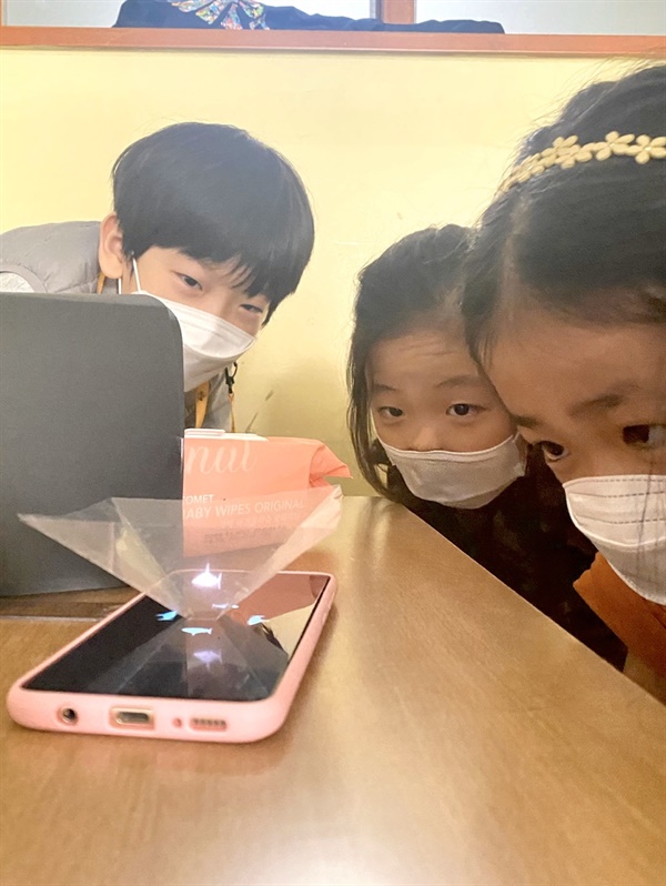 4학년 홀로그램 사진 휴대폰에 홀로그램 재생용 영상을 다운받아 아이들이 홀로그램을 직접 관찰하는 모습
