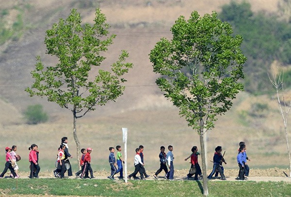 과외 활동을 위해 줄지어 발걸음을 옮기는 북한의 어린이들
