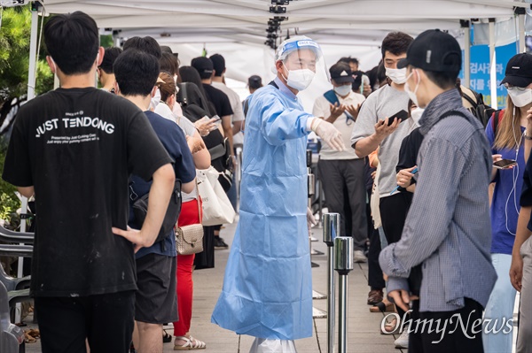 폭염특보가 내린 22일 오후 서울 종로구 탑골공원 앞 선별검사소에서 시민들이 코로나19 검사를 받기 위해 줄 서 있다.