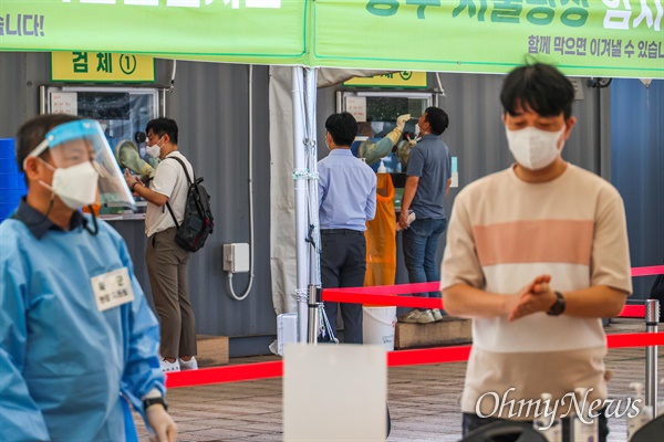 5일 오전 서울시청앞에 설치된 코로나19 임시선별진료소에서 시민들이 검체 채취를 하고 있다.