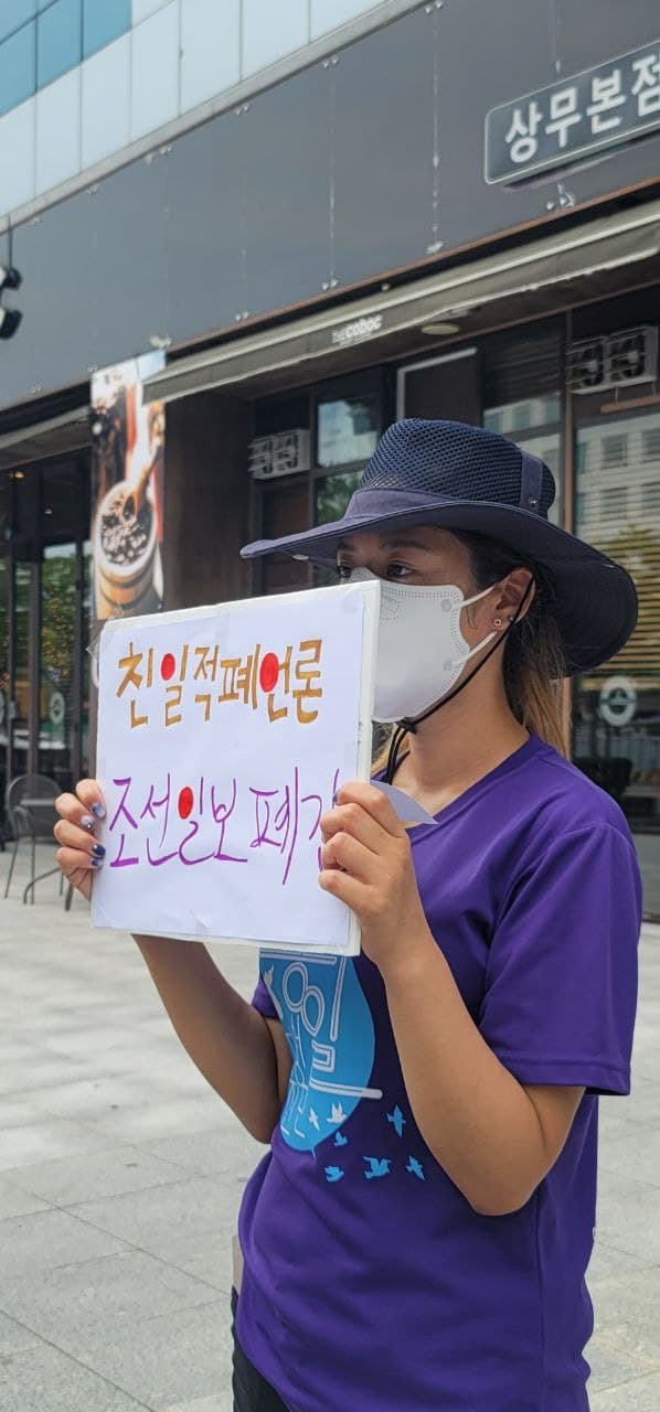 12일 오후, 광주광역시 서구에 위치한 조선일보 광주지사 앞에서 광주전남대학생진보연합 통일대행진단이 조선일보의 폐간을 촉구하는 기자회견이 진행되고 있는 가운데, 한 참가자가 규탄 피켓을 들고 있다.
