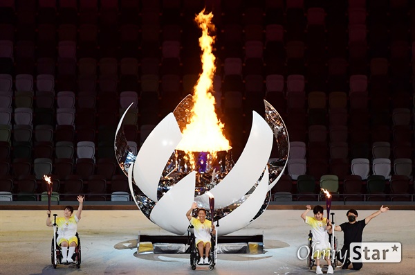 2020 도쿄 패럴림픽 개회식이 24일 오후 8시 일본 도쿄 국립경기장(올림픽 스타디움)에서 열렸다. 최종 주자 3명이 성화대에 불을 붙이고 있다.