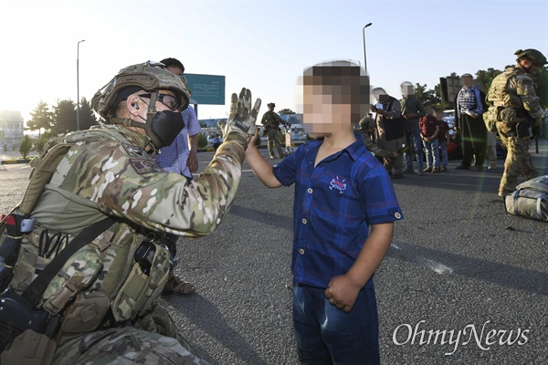 공군 최정예 특수부대 요원인 공정통제사(CCT : Combat Control Team)가 8월 25일(수) 아프가니스탄 카불공항에서 한국으로 이송될 아프간인 현지 조력자 자녀와 반갑게 인사하고 있다.