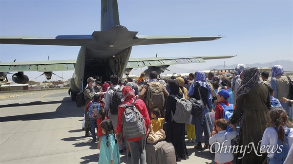 한국으로 이송될 아프간인 현지 조력자와 가족들이 8월 25일(수) 아프가니스탄 카불공항에서 공군 C-130J 수퍼허큘리스 수송기에 탑승하기 위해 대기하고 있다.
