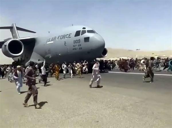 지난 16일 아프가니스탄 카불 국제공항에서 수백 명의 사람들이 미 공군 C-17 수송기가 활주로를 주행할 때 함께 달려가고 있다. 
