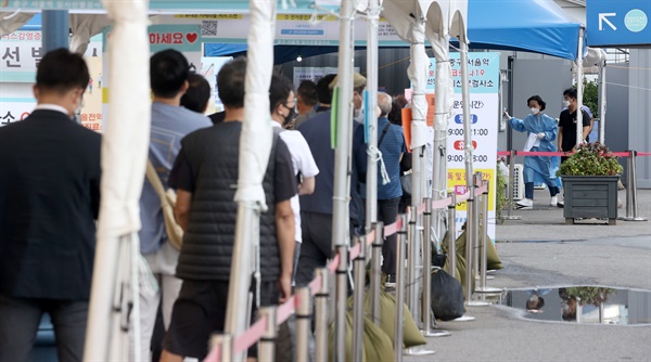 신종 코로나바이러스 감염증(코로나19) 신규 확진자 수가 1605명을 기록한 20일 오전 서울역 코로나19 선별진료소을 찾은 시민들이 검사를 기다리고 있다.