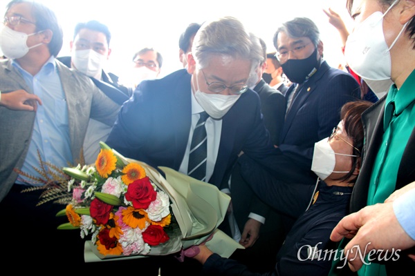 이재명 후보가 24일 오후 경남도의회에 들러서면서 한 지지자로부터 꽃다발을 받고 있다.