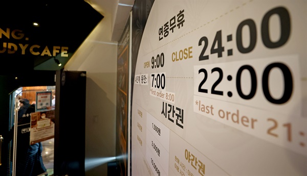 정부가 오는 18일부터 방역지침을 일부 완화하기로 발표한 15일 오후 서울의 한 스터디카페에 기존 영업시간과 현행 거리두기 4단계 영업시간이 함께 적혀 있다. 새 방역지침에 따르면 4단계 지역의 식당·카페 영업시간은 오후 10시까지로 계속 제한되지만 독서실·스터디카페·공연장·영화관은 자정까지 운영 시간이 확대된다.