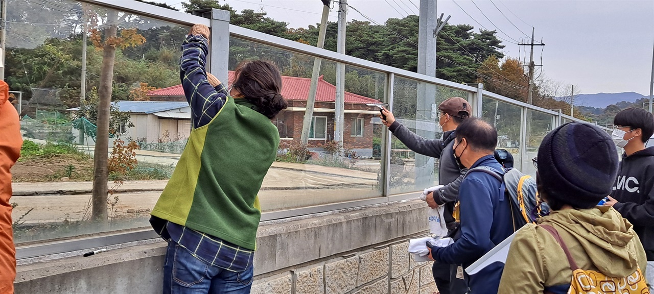 예산홍성환경운동연합 회원들과 홍성군자원봉사센터 자원 봉사자들이 조류충돌 방지 스티커를 붙이고 있다. 
