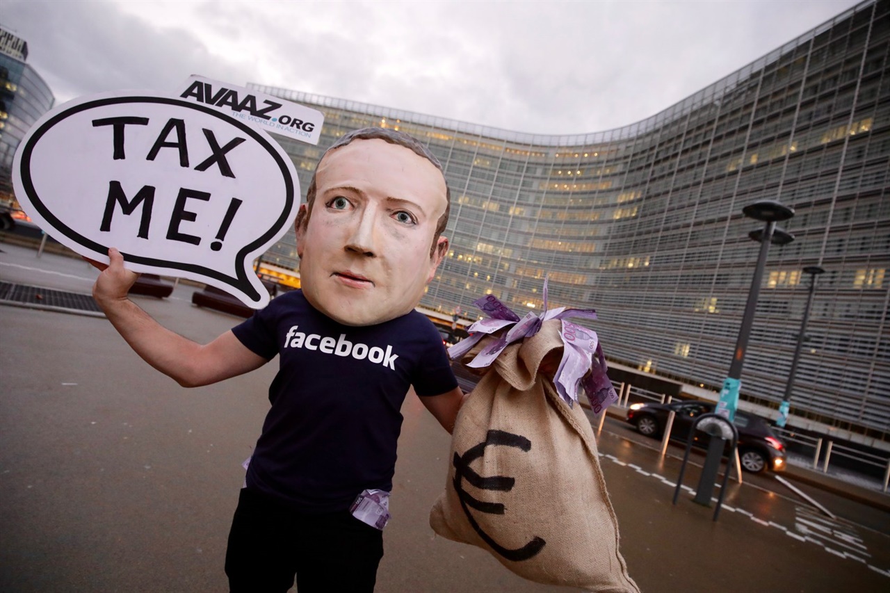 2018년 브뤼셀 유럽연합 본부 앞에서 한 활동가가 '구글세' 도입을 주장하며 페이스북 CEO 마크 저커버그 복장을 하고 1인시위를 하고 있다.