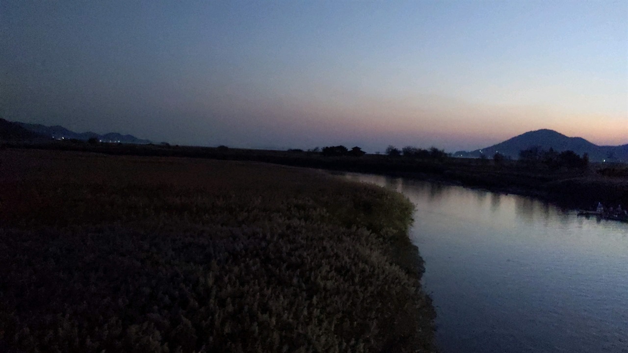 무진교 아래 고요히흐르는 강물 푸르스름한 기운을 받은 빛이 푸른 강물 위로 갈대 그림자를 만들고 있다