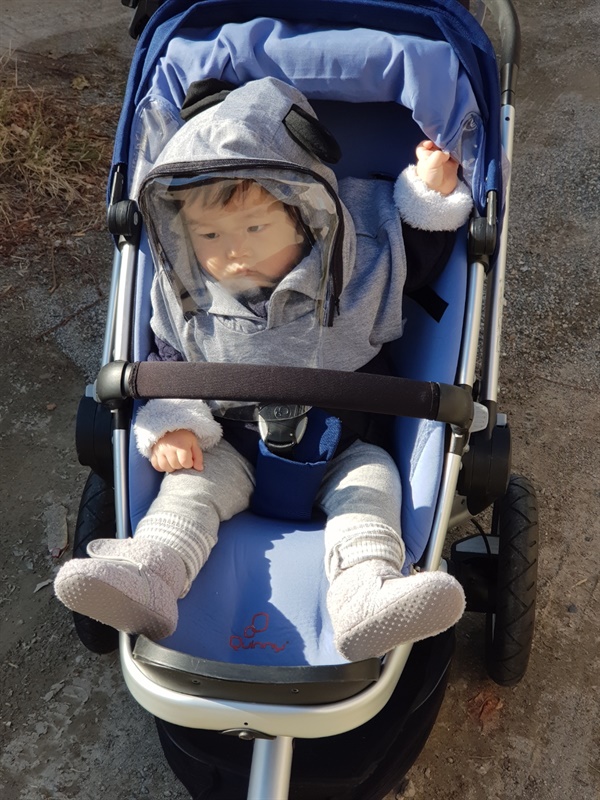 유모차에서 우주복을 실제로 처음 착용한 날의 모습. 아기 엄마와 산책을 하는 중의 모습이다. 표정을 보시라 잔뜩 불만인 표정이다.
