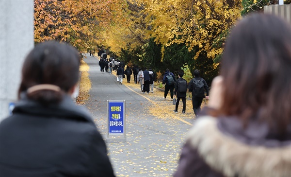 대학수학능력시험(수능)일인 18일 오전 서울의 한 고등학교에서 학부모들이 고사장으로 향하는 학생들을 바라보고 있다.