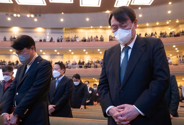국민의힘 윤석열 대선후보가 지난 21일 서울 서초구 사랑의 교회에서 열린 예배에서 기도하고 있다. 왼쪽으로는 장제원 국민의힘 의원. 