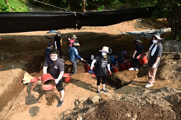 김요섭 연출가(왼쪽)가 산내 골령골 유해발굴 자원봉사로 참여해 발굴단이 파낸 흙을 밖으로 퍼 나르고 있다.