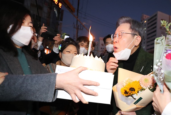 더불어민주당 이재명 대선후보가 생일인 27일 전남 순천시 연향상가 패션거리를 부인 김혜경 씨와 함께 방문, 생일 케이크 선물을 받고 불을 끄고 있다. 