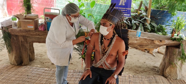 브라질 원주민 청년에게 코로나 백신을 접종하는 모습이다.