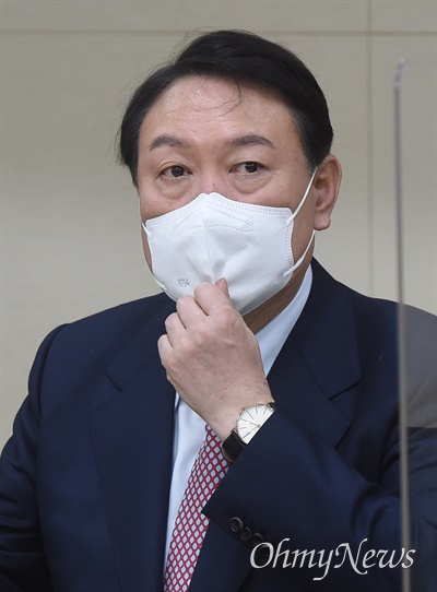 국민의힘 윤석열 대선 후보가 지난 21일 서울 강남구 한국과학기술회관에서 열린 정책간담회에서 마스크를 고쳐쓰고 있다.