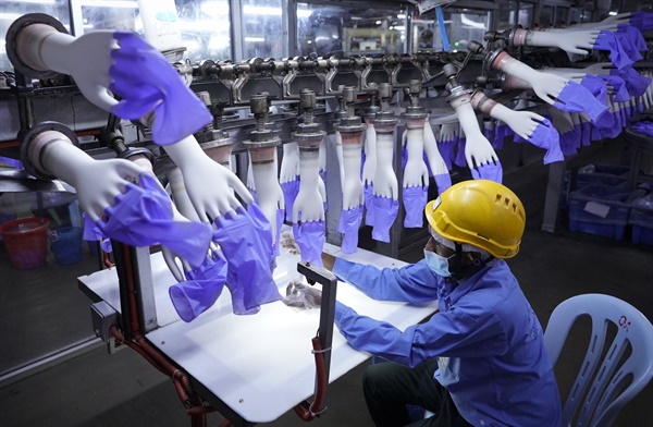 2020년 8월 26일, 말레이시아 쿠알라룸푸르 외곽에 있는 세계 최대 고무장갑 제조업체인 탑 글러브 공장에서 노동자가 일회용 장갑을 검사하고 있다. 